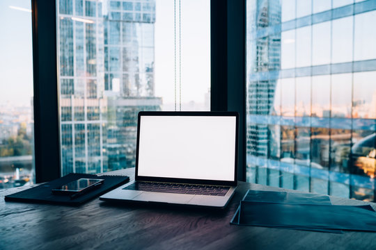 Image Of Modern Working Space With Equipment And Panoramic Windows In Office Interior, Open Laptop Computer With Mock Up Screen And Contemporary Software For Job Standing On Wooden Table