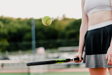 woman playing with tennis ball and racket on court