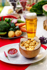 fried dumplings in wooden utensils with hot pepper and beer