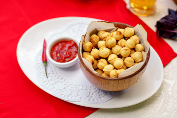 fried dumplings in wooden utensils with hot pepper and beer