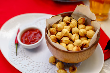 fried dumplings in wooden utensils with hot pepper and beer