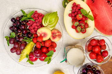 berries and fruit in a transparent plate. Apples, pears, cherries, raspberries, plums, grapes.