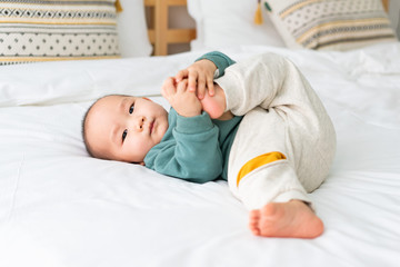 Asian infants crawling and playing on bed