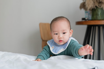 Asian baby in the room reaches for something