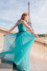 a girl in Paris in a green dress against the backdrop of the Eiffel tower elegant on the Trocadero...