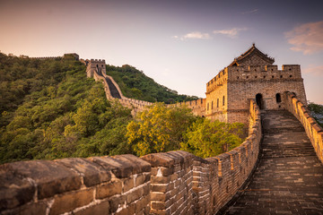 Golden sunlight blankets the Great Wall of China on a moody, cloudy, afternoon near Beijing, China.