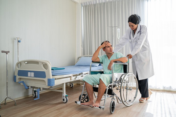 Fototapeta premium The african american doctor is pushing the wheelchair And provide consultation regarding treatment to patients sitting in a wheelchair and closely monitor