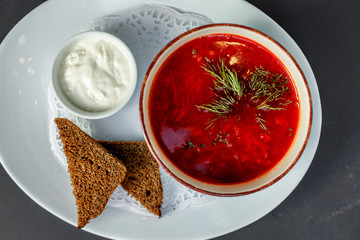 Russian dish borsch with rye bread and sour cream
