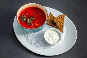 Russian dish borsch with rye bread and sour cream