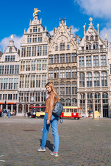 Obraz premium Young woman tourist walking on the Great Market square during the morning in Antwerpen