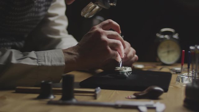 watchmaker repairs an old clock close up