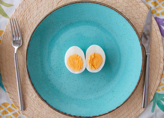 
breakfast plate and cut egg standing in blue plate