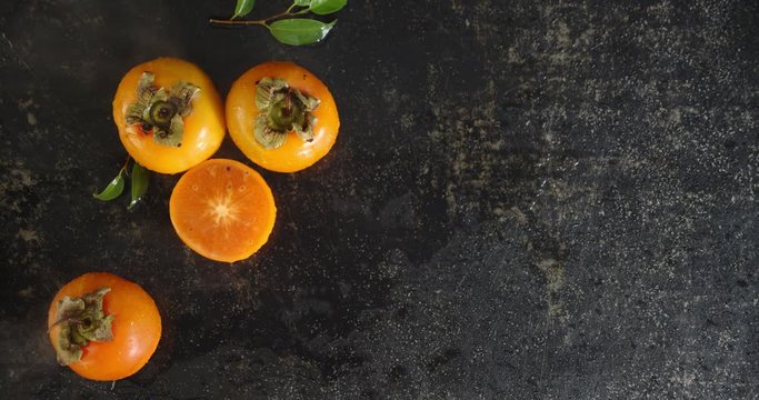 Whole and sliced persimmon with cool steam.