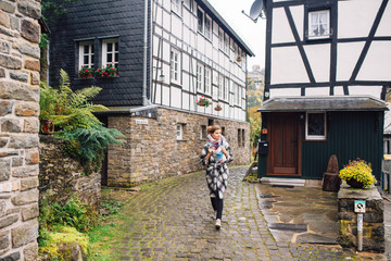 a girl in a coat walks in Monschau, despite the wet weather