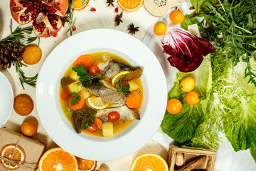 Russian soup with fish in a plate and ingredients served on the table