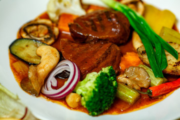 juicy steaks with grilled broccoli vegetables and mushrooms served on the table