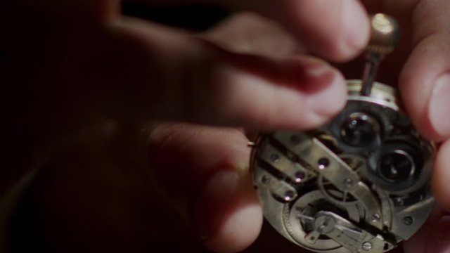 watchmaker repairs an old clock close up