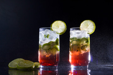 Campari drink with gin with ice and lemon on black background