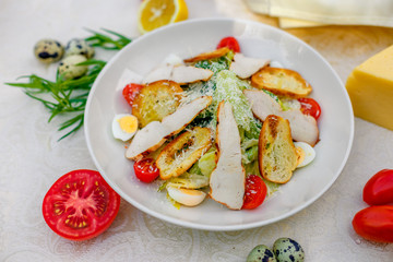 Caesar salad with chicken vegetables and herbs, healthy food on the table