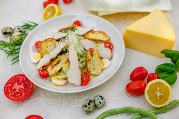 Caesar salad with chicken vegetables and herbs, healthy food on the table