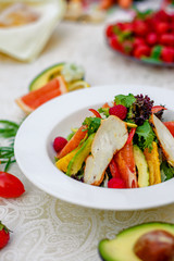 salad with chicken vegetables and herbs, healthy food on the table