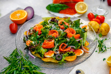 fresh salad with vegetables, greens and red fish with caviar served on the table, healthy food