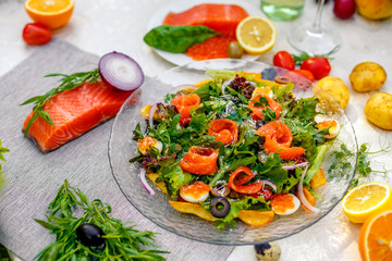 fresh salad with vegetables, greens and red fish with caviar served on the table, healthy food