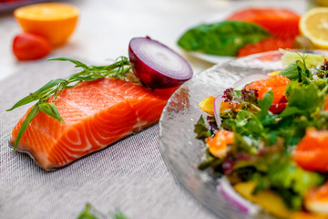 fresh salad with vegetables, greens and red fish with caviar served on the table, healthy food