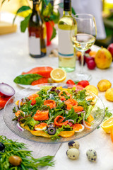 fresh salad with vegetables, greens and red fish with caviar served on the table, healthy food