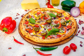 Delicious italian pizza served on table with ingredients cheese and vegetables