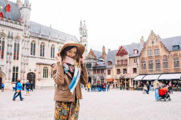 Fototapeta premium dziewczyna patrzy na zabytkowy budynek w Brugii