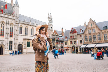Naklejka premium a girl looks at a historic building in Bruges