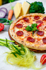 Delicious italian pizza served on table with ingredients cheese and vegetables