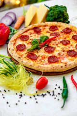 Delicious italian pizza served on table with ingredients cheese and vegetables
