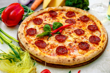Delicious italian pizza served on table with ingredients cheese and vegetables