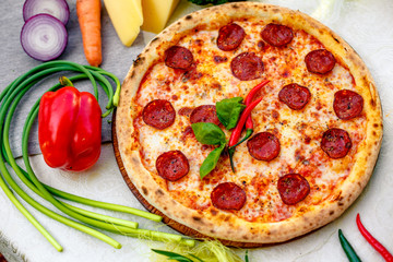 Delicious italian pizza served on table with ingredients cheese and vegetables