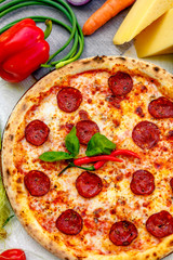 Delicious italian pizza served on table with ingredients cheese and vegetables