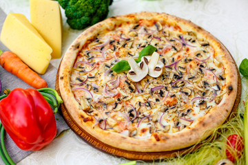 Delicious italian pizza served on table with ingredients cheese and vegetables