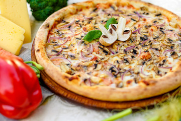 Delicious italian pizza served on table with ingredients cheese and vegetables