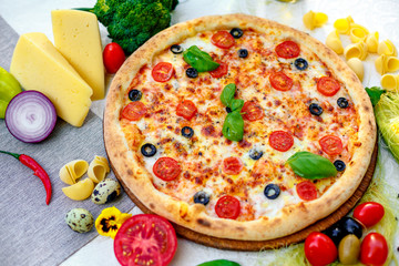 Delicious italian pizza served on table with ingredients cheese and vegetables