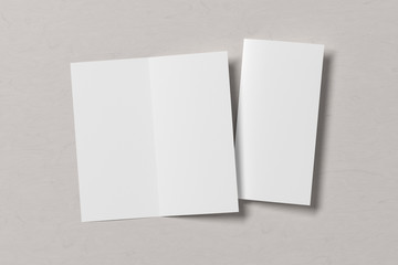 Blank square leaflet on white wooden background. Bi-fold or half-fold opened and folded brochure isolated with clipping path. View directly above. 3d illustration