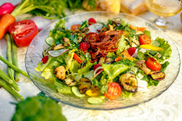 Fresh salad with dried meat, herbs and vegetables served on the table with the ingredients, healthy food