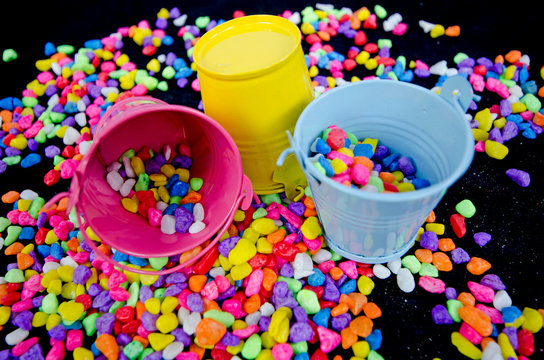 Colored buckets and beautiful river rocks