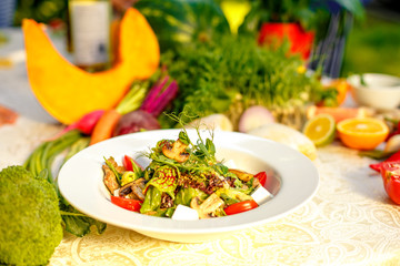 Fresh salad with mushrooms, cheese, tomatoes, herbs and vegetables served on the table with the ingredients, healthy food
