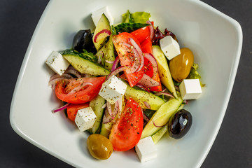 fresh greek salad with tomatoes, feta cheese, onions, olives and cucumbers, healthy food, isolated