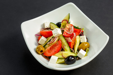 fresh greek salad with tomatoes, feta cheese, onions, olives and cucumbers, healthy food, isolated