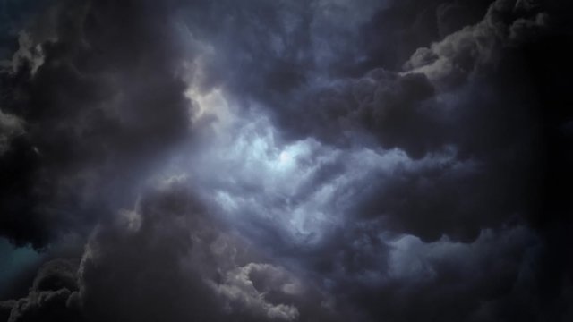 Flying through storm clouds. 4K realistic animated fly through of dark storm clouds in the sky. The camera spins slowly as lightning flashes.