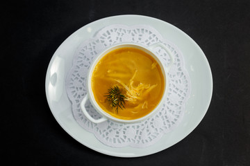 hot noodle soup with chicken and broth on a white plate