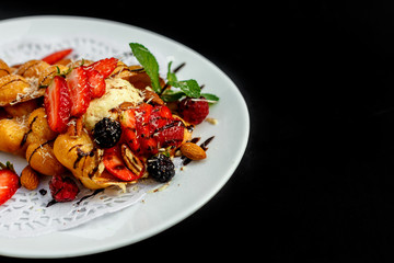 Waffles - a ball of Italian ice cream with berries and nuts and fresh fruit