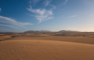 Fototapeta na wymiar Ripples on sand dune near Corralejo with volcano mountains in the background, Fuerteventura, Canary Islands, Spain. October 2019